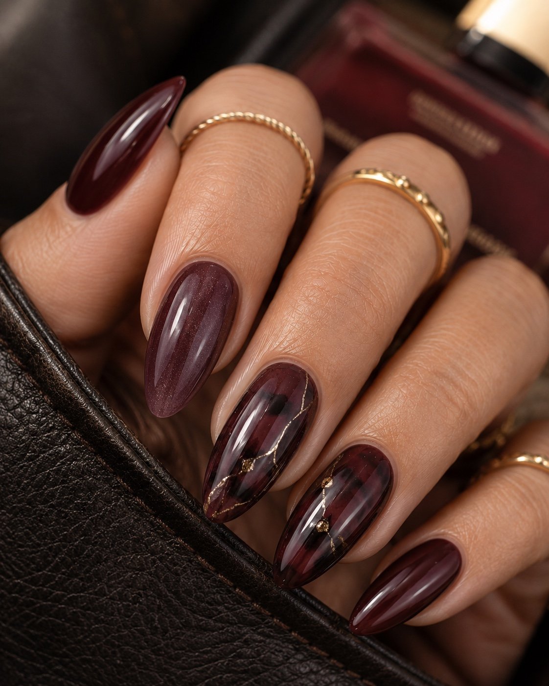 Smoky plum jelly almond nails with black cherry accents and fine gold veining