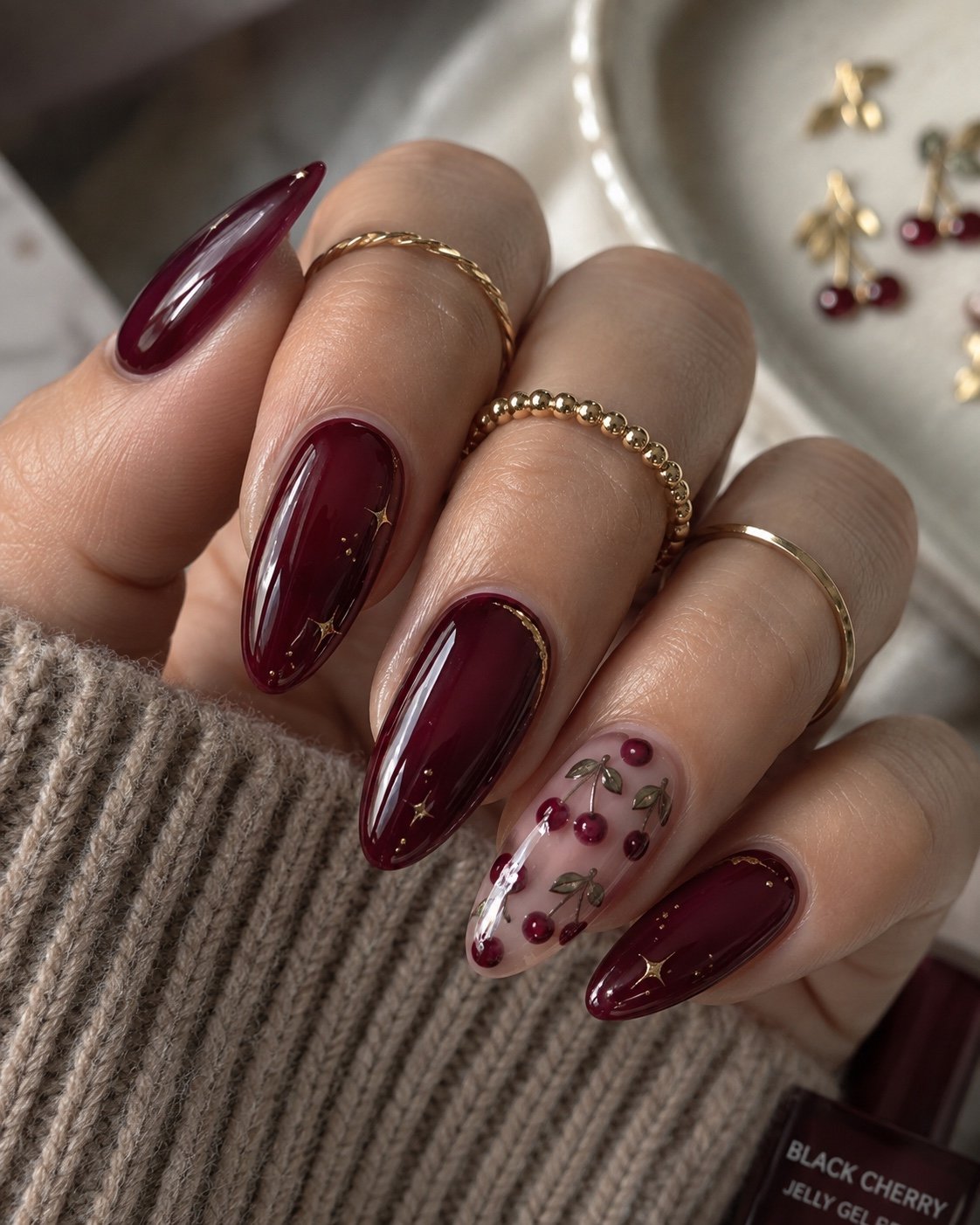Black cherry jelly almond nails with tiny cherry nail art and gold stars