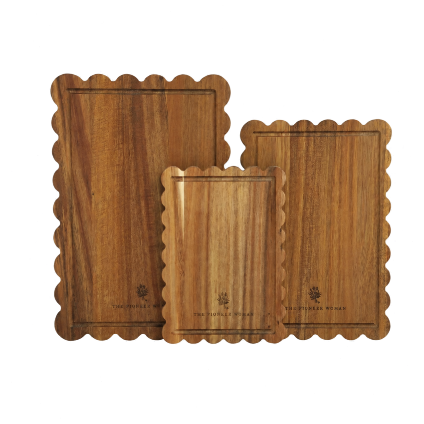 Three warm acacia wood cutting boards with scalloped edges