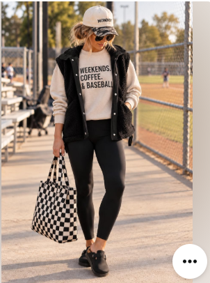 Casual baseball-mom outfit with a graphic sweatshirt, vest, leggings, cap, sneakers, and checkered tote